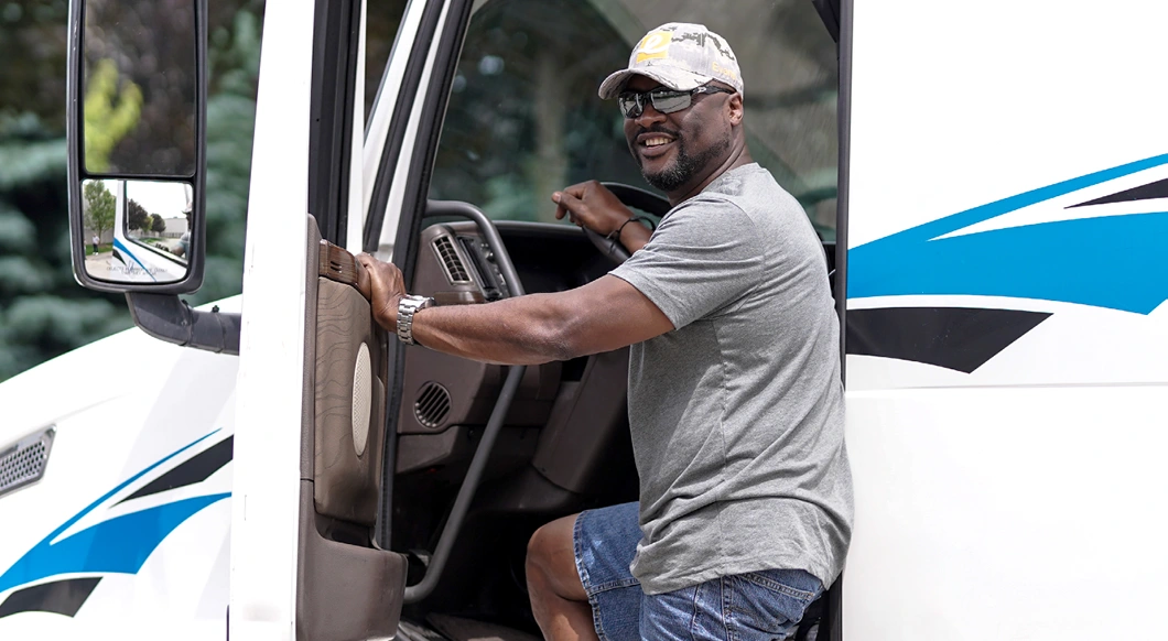 Person smiling at camera getting into truck