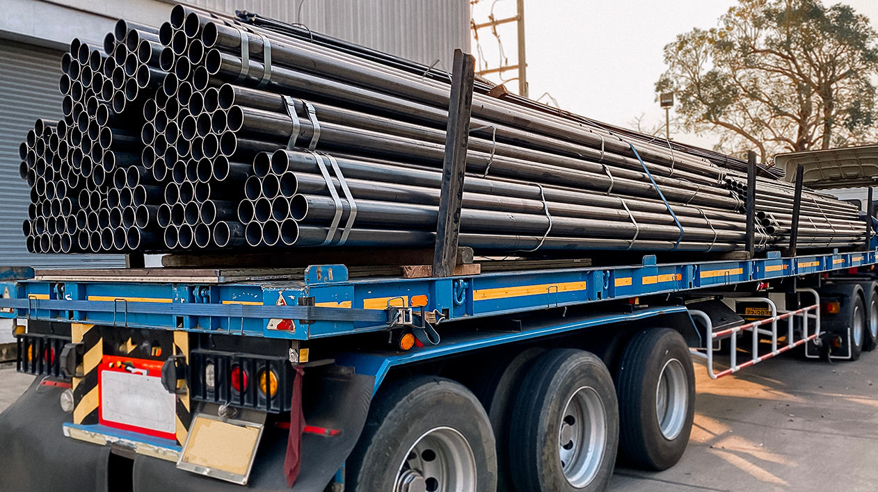 Blue flatbed truck with pipes for materials receiving