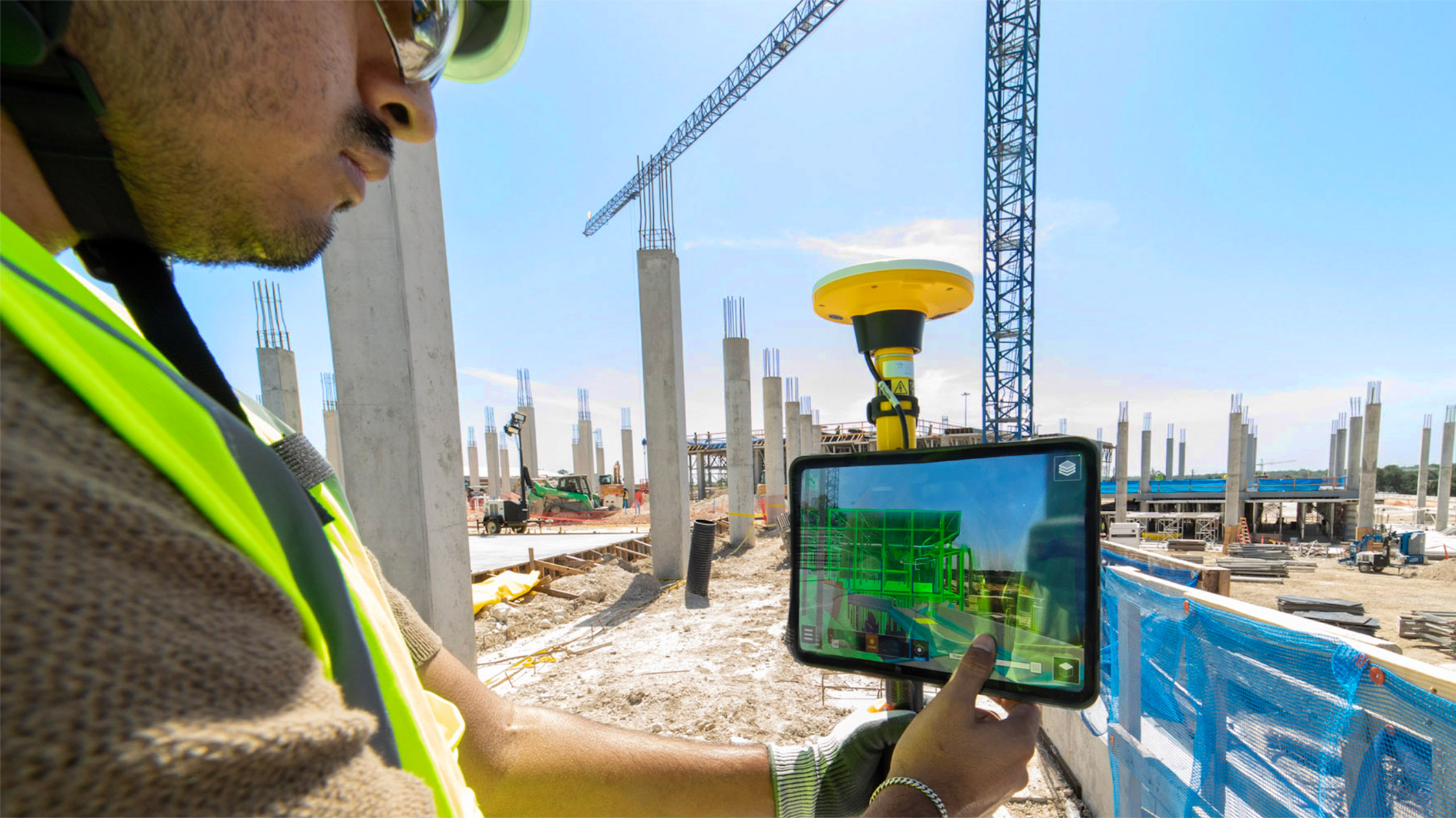 JE Dunn employee using an iPad on-site to compare real-world jobsite conditions with the digital building model for accuracy and alignment.