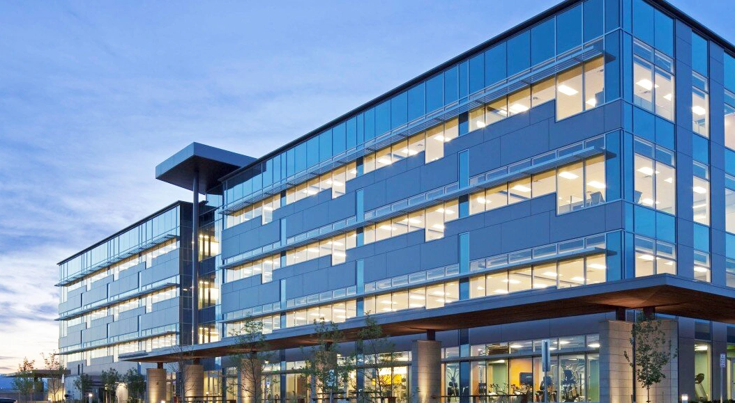 The Trimble headquarters in Westminster, Colorado, featuring a modern glass facade illuminated at dusk.