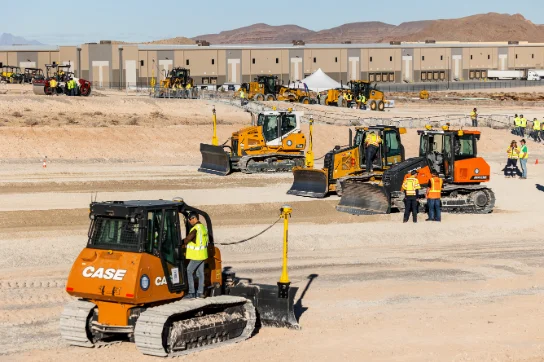 Various heavy machinery spread across a desert backdrop, with operators stationed at every machine