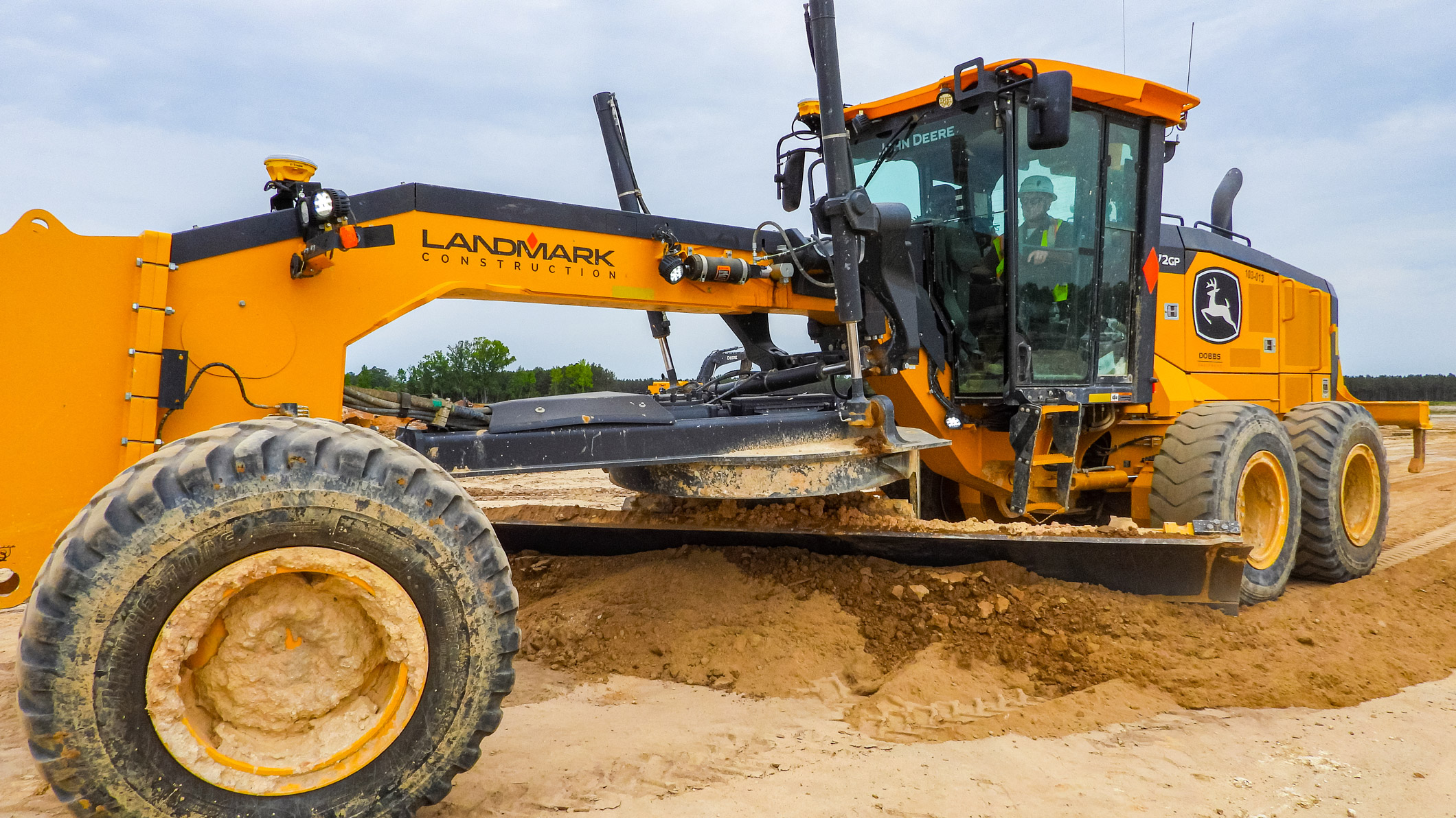 A Landmark Construction heavy equipment operator uses a grader to level the ground at the South Carolina EV manufacturing plant job site.