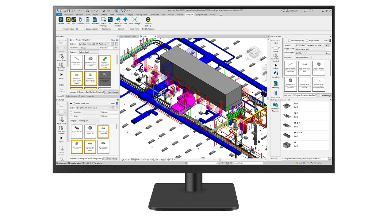 A desktop monitor displays Trimble SysQue software.