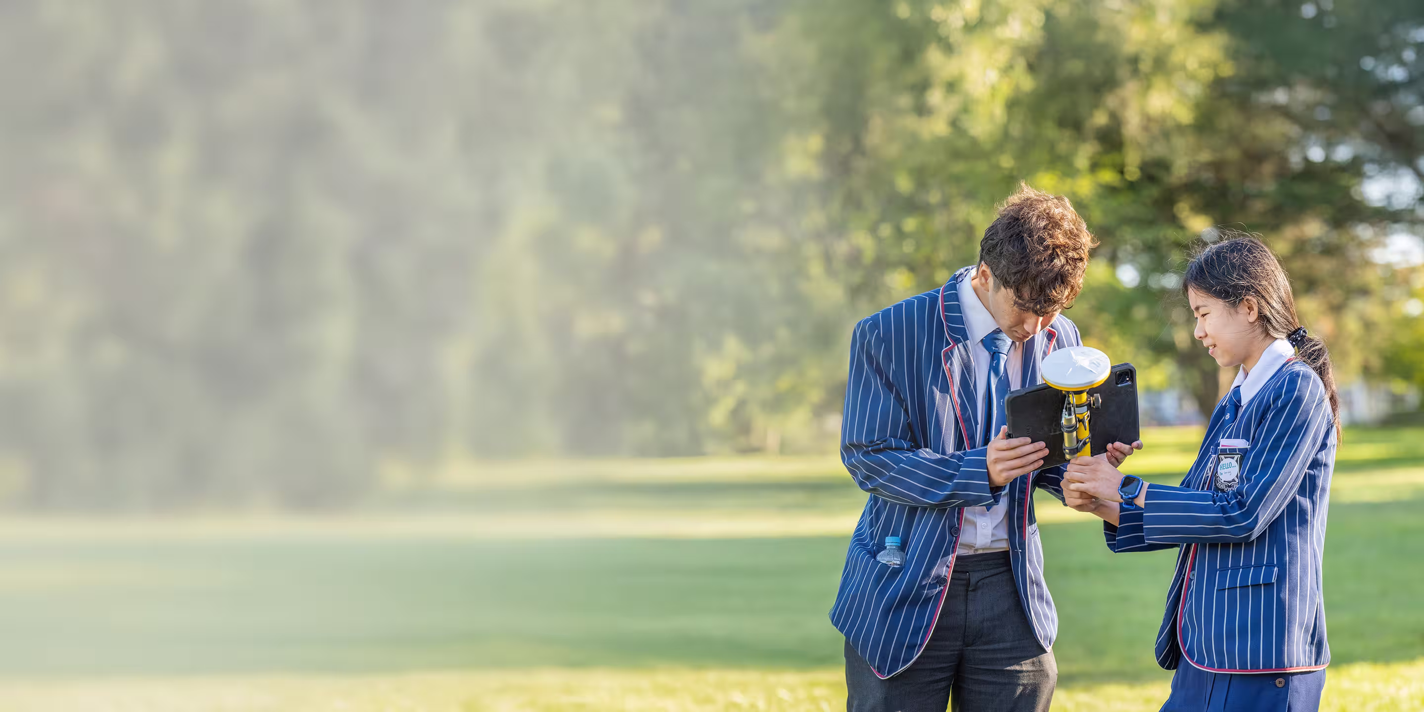 Two students in striped blazers using Trimble SiteVision outdoors during a career day in Christchurch, NZ