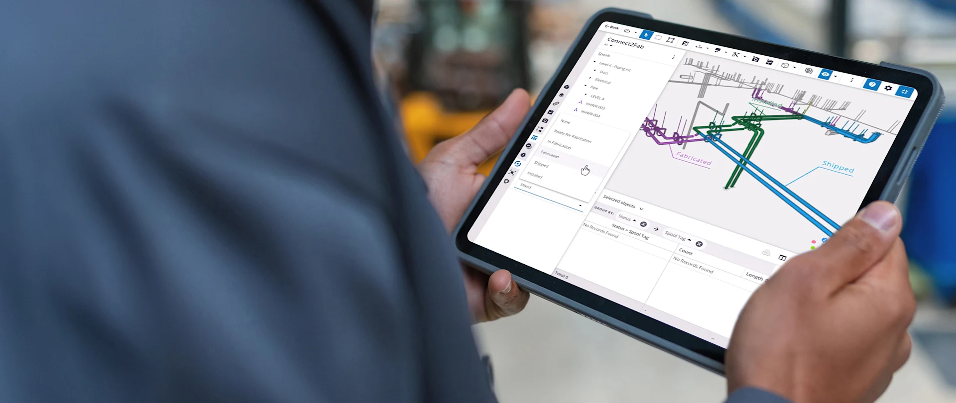 A person holds a tablet displaying the Trimble Connect2Fab user interface.