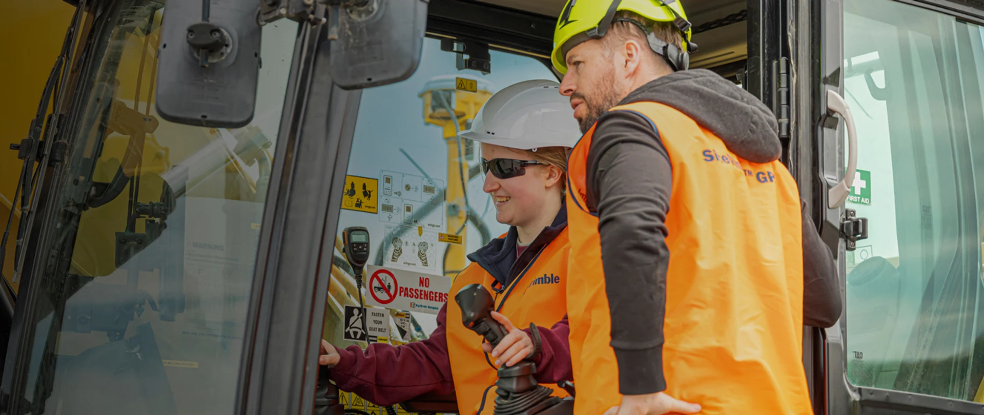 People in hard hats and Trimble vests operating heavy machinery
