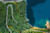 Aerial view of winding road in forest next to sea