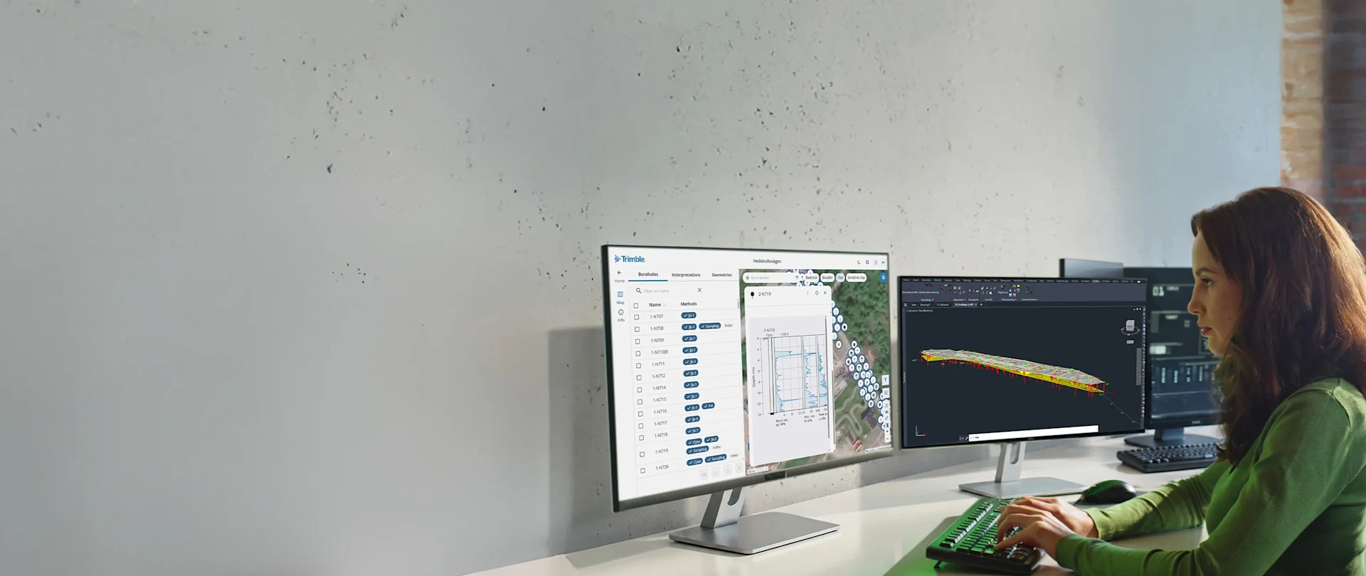 A geotechnical engineer at a desk using Geosuite to perform geotechnical analysis and design for a multidisciplinary highway and utility project.