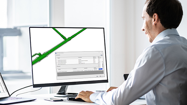 A man works on a computer using Trimble Nova software to design a 3D green piping system with a technical data dialog box open on the screen.