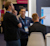 A group of professional attendees discussing a digital display and sharing ideas at the Trimble Dimensions conference.
