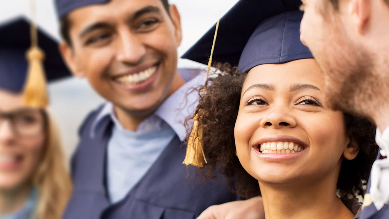 Diverse, smiling students at graduation wearing mortarboards