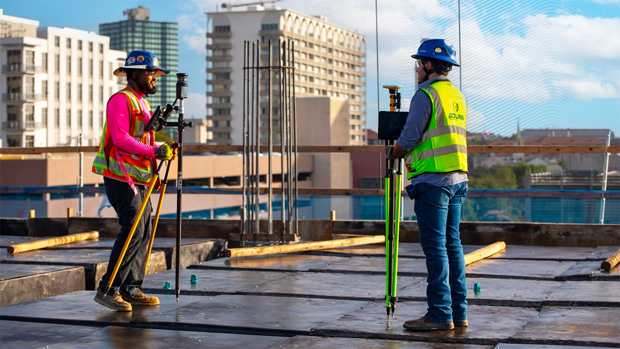 Two JE Dunn employees verifying concrete layout on-site using Trimble equipment, ensuring predictable precision and accuracy.
