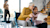 Man kneeling next to woman in wheelchair looking at tablet