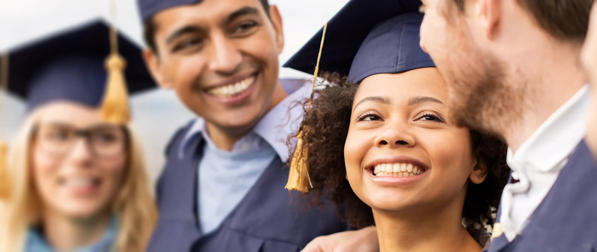 Diverse, smiling students at graduation wearing mortarboards