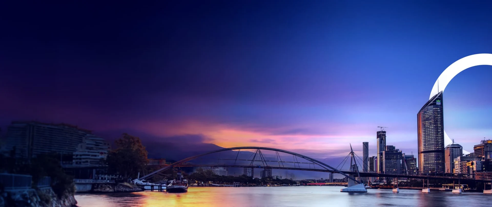 Panoramic sunset view of the Brisbane city skyline and Goodwill Bridge, overlaid with a large white ring symbolizing Trimble’s connected technology.