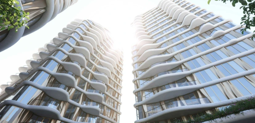 Modern high-rise buildings with wavy white facades and glass, featuring greenery, under a bright, sunny sky.