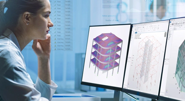An engineer analyzes 3D structural models in Trimble Tekla software across multiple monitors, showing 'Pass' and 'Warning' validation results.