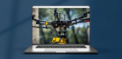 A professional drone equipped with a yellow payload flies in front of a blurred background of trees.