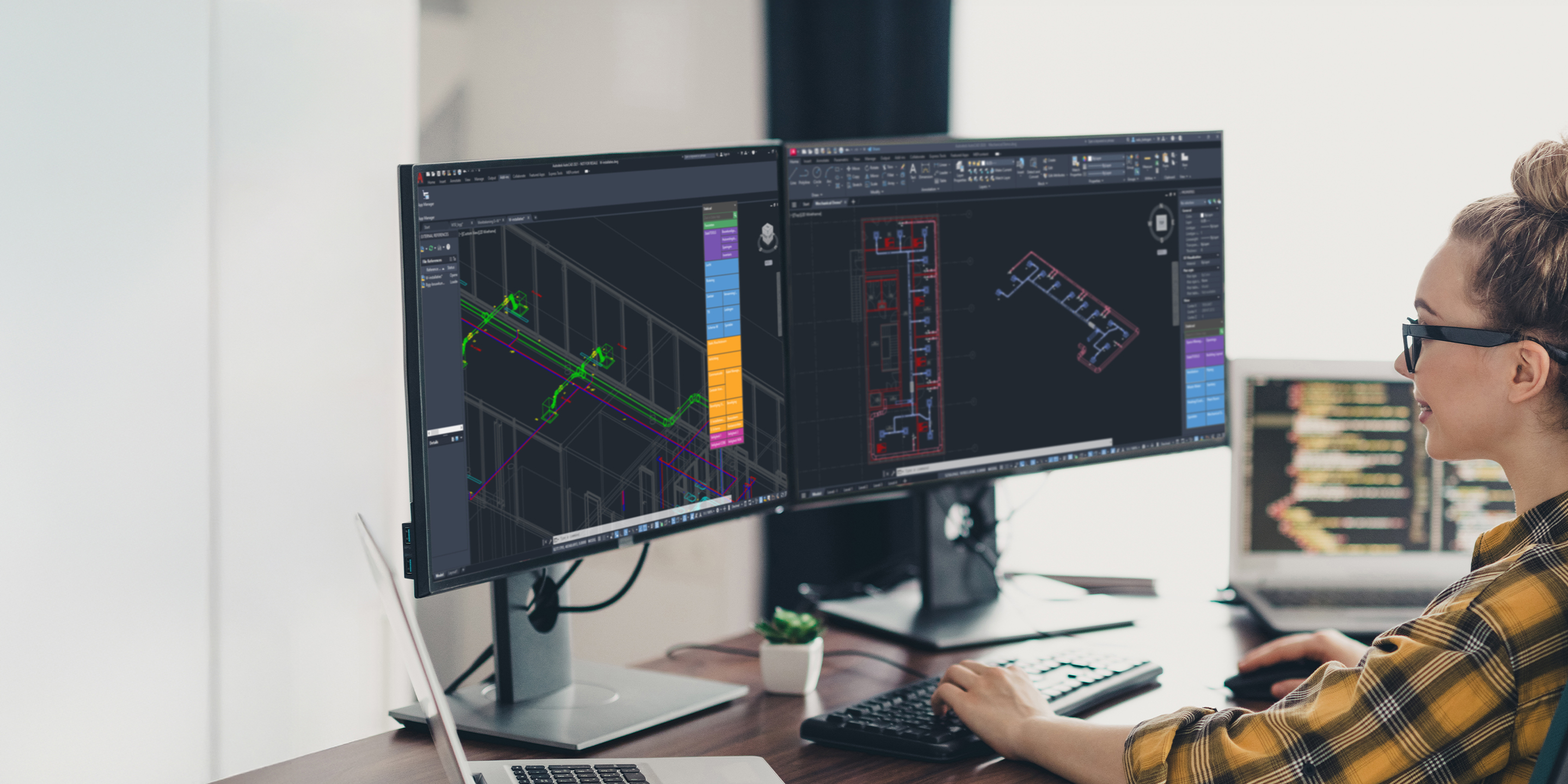 An engineer works at a desk using Stabicad for AutoCAD on dual monitors to design MEP systems