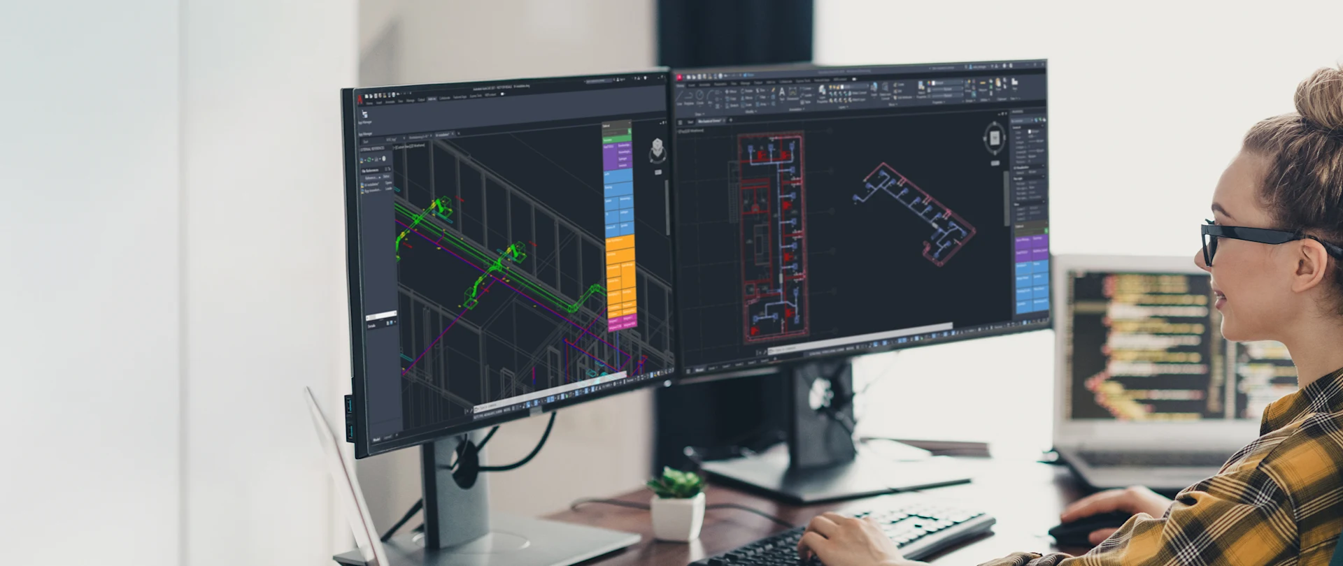 Dans un bureau, un ingénieur utilise Stabicad for AutoCAD sur deux moniteurs pour concevoir des systèmes MEP.
