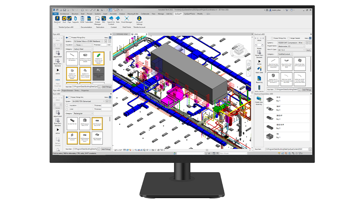 A desktop monitor displays Trimble SysQue software.