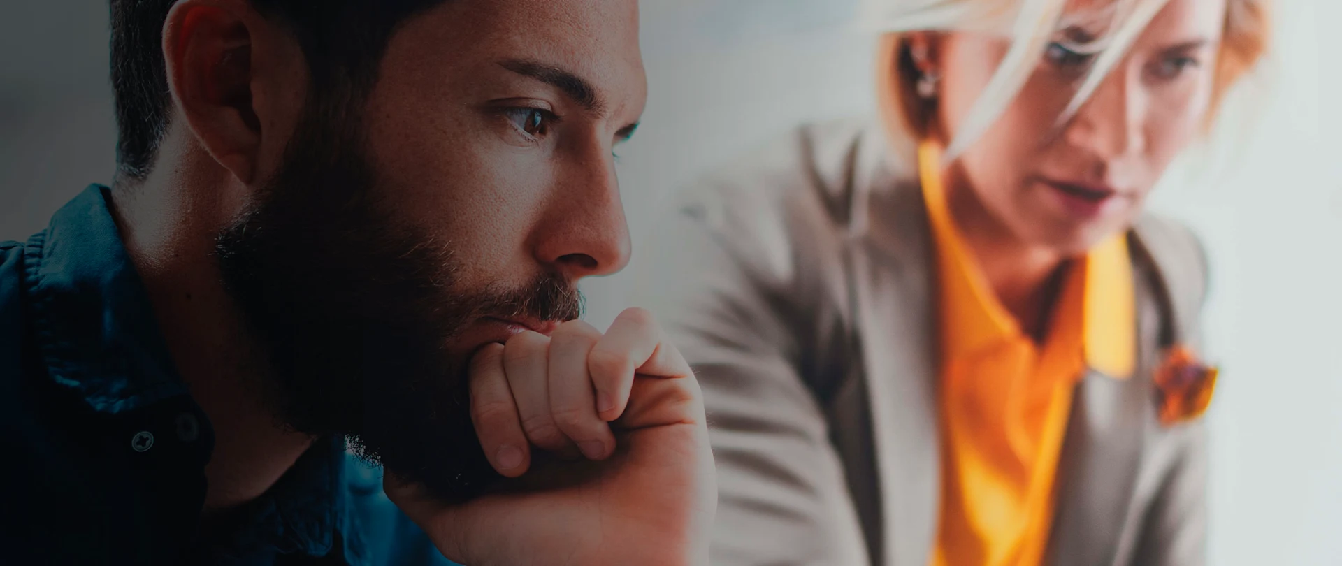 A close-up, side profile shot focuses on a bearded man with a contemplative expression, his hand resting near his chin.