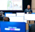 A presenter stands before a classroom of attendees using monitors to follow a technical demonstration at the Trimble Developer Summit.
