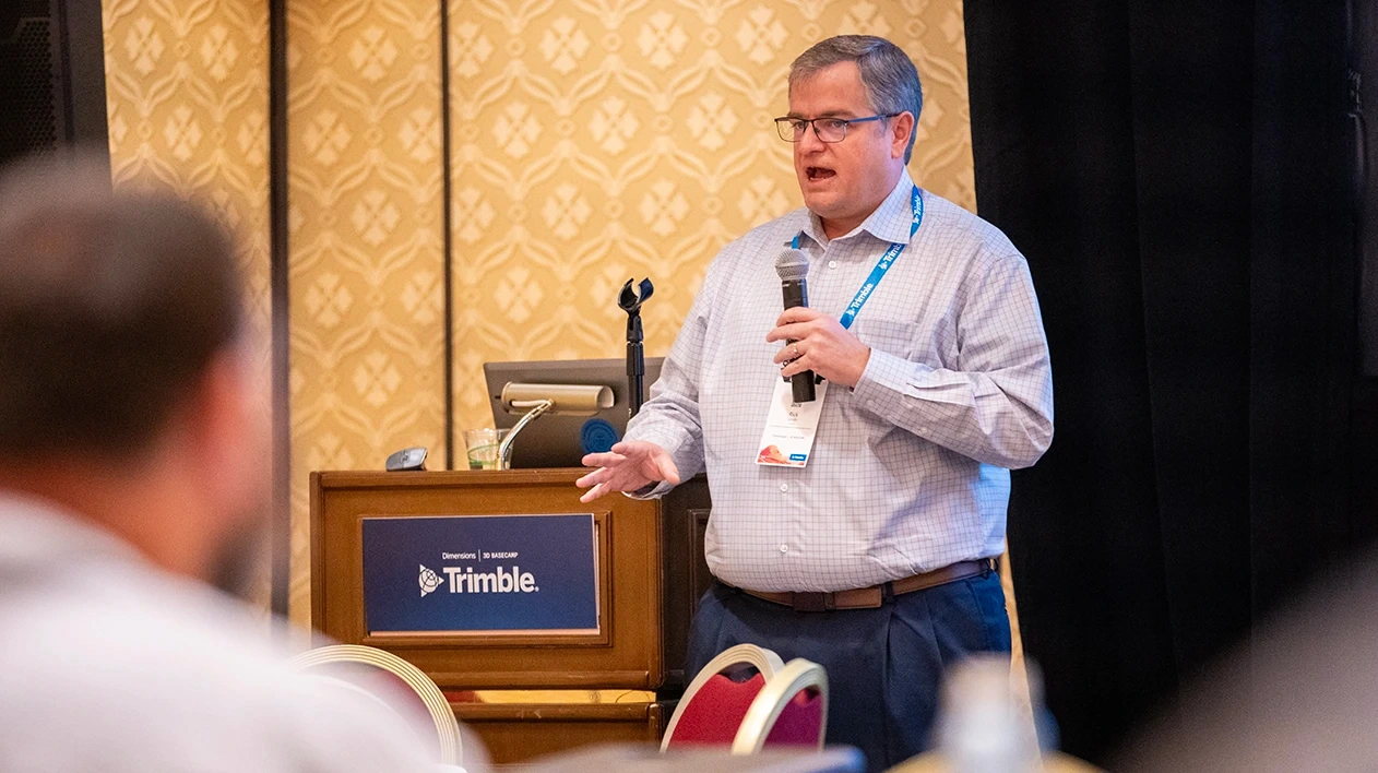 A Dimensions speaker stands at the front of the room and confidently addresses attendees.