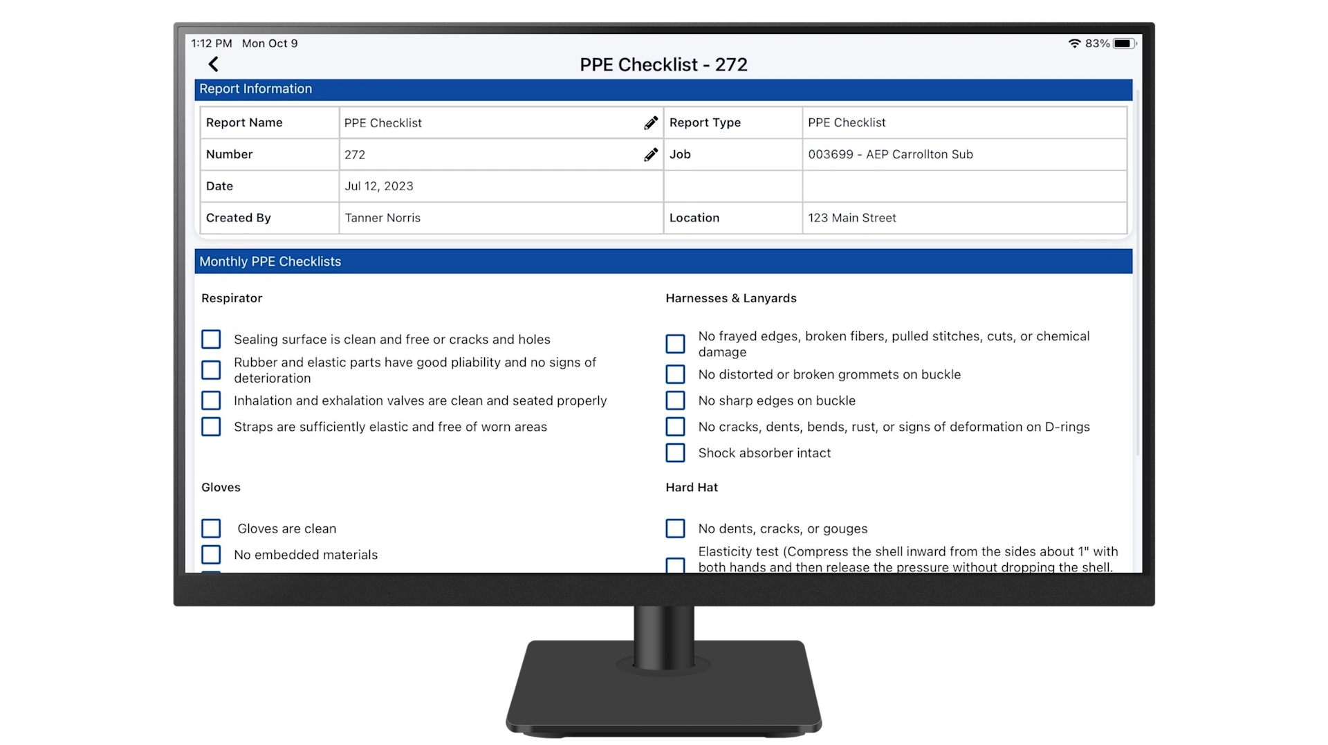 A monitor displaying a digital PPE Checklist with safety inspection categories for field equipment in a Trimble construction management app.