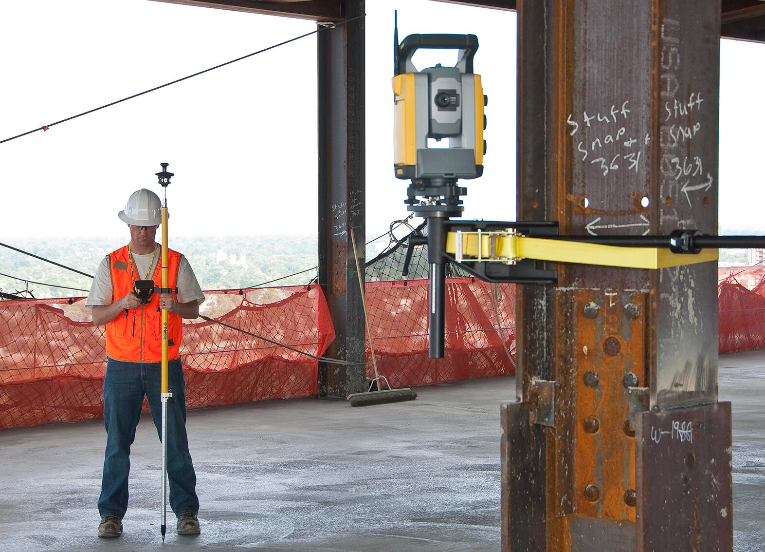 Mann in einem Gebäude benutzt eine Robotik-Totalstation