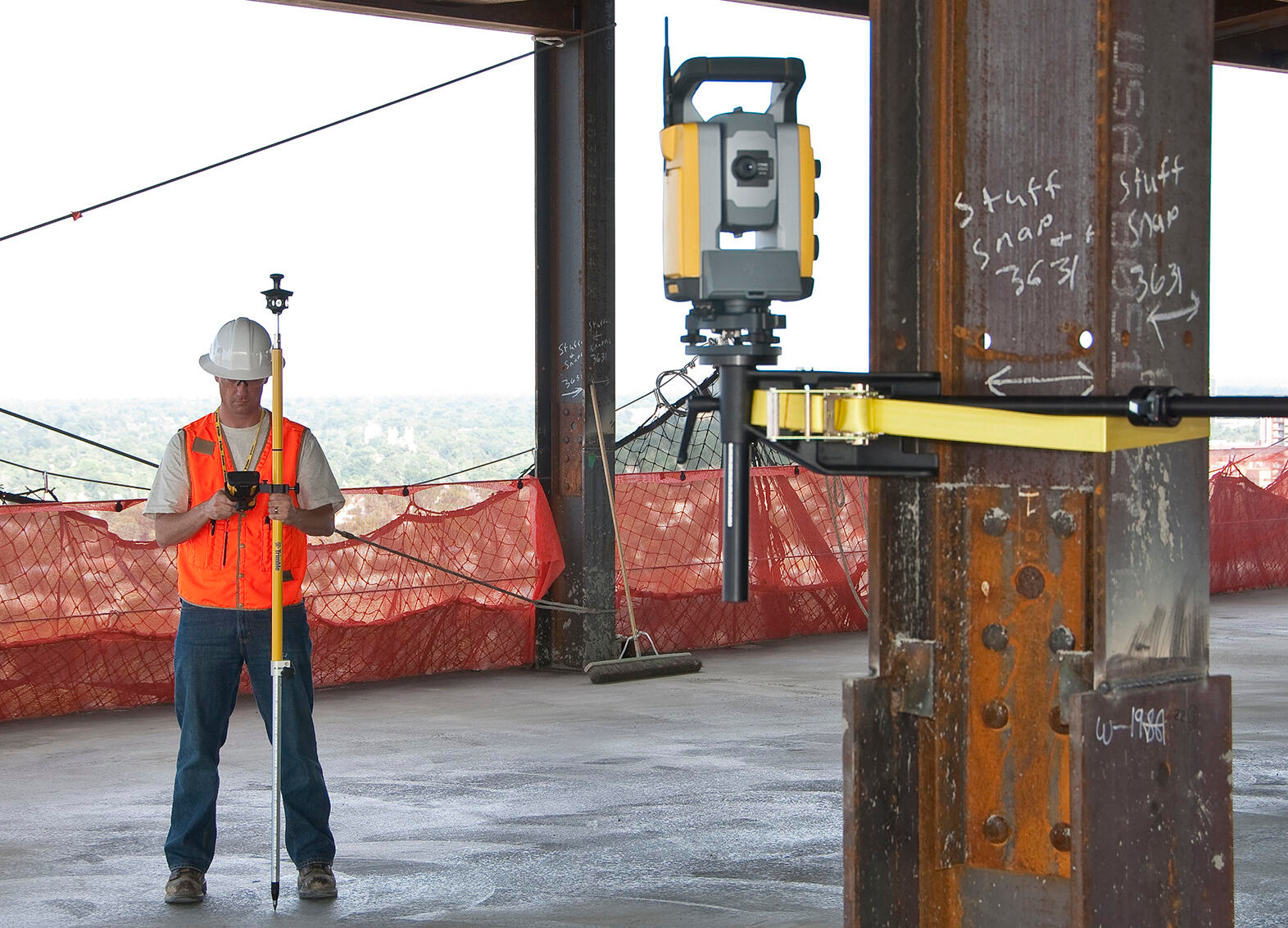 Man using a robotic total station in a building