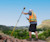 Man with reflective vest using Trimble Geospatial equipment on a plateau