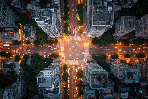 Aerial view of city skyscrapers and busy intersection at night
