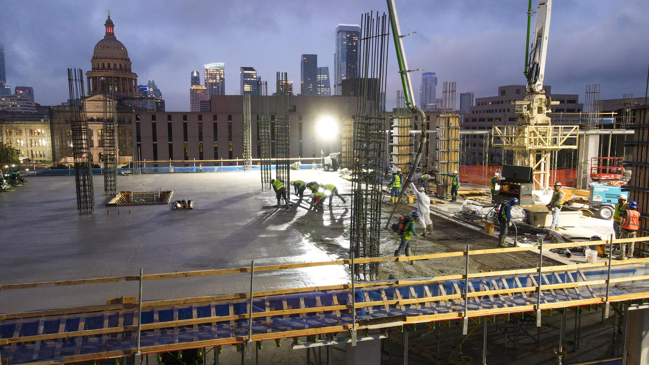 JE Dunn crew conducting an early morning concrete pour at a construction site in Austin, Texas.