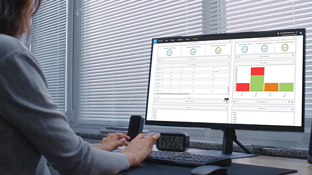 A professional analyzing real-time construction analytics and progress charts on a computer screen at a desk.