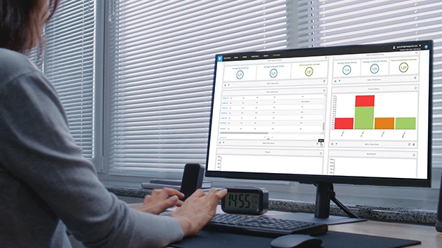 A professional analyzing real-time construction analytics and progress charts on a computer screen at a desk.