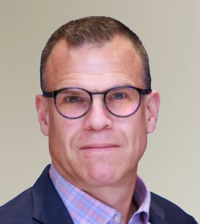 Headshot of Sean Young from NVIDIA is wearing dark-rimmed glasses, a blue blazer, and a pink and blue checkered shirt.