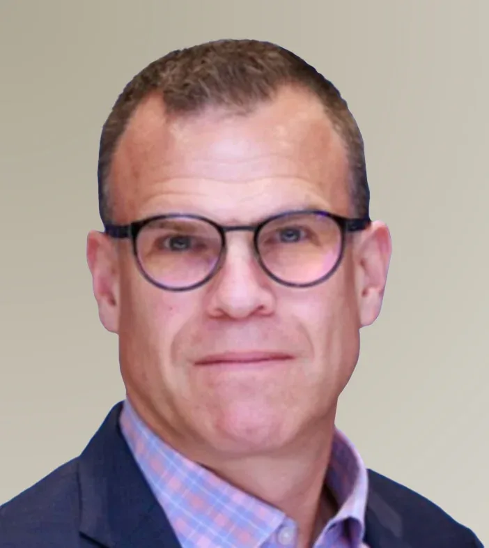 Headshot of Sean Young from NVIDIA is wearing dark-rimmed glasses, a blue blazer, and a pink and blue checkered shirt.