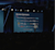 An auditorium stage screen titled "Bronze Sponsors" displays multiple rows of company logos. A presenter stands to the right of the screen in front of a large, seated audience in a dimly lit conference hall.