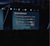 An auditorium stage screen titled "Bronze Sponsors" displays multiple rows of company logos. A presenter stands to the right of the screen in front of a large, seated audience in a dimly lit conference hall.