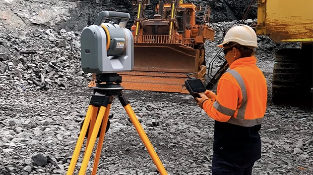 Person at mining site in safety equipment using Trimble SX12