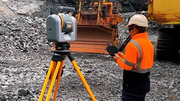 Person at mining site in safety equipment using Trimble SX12