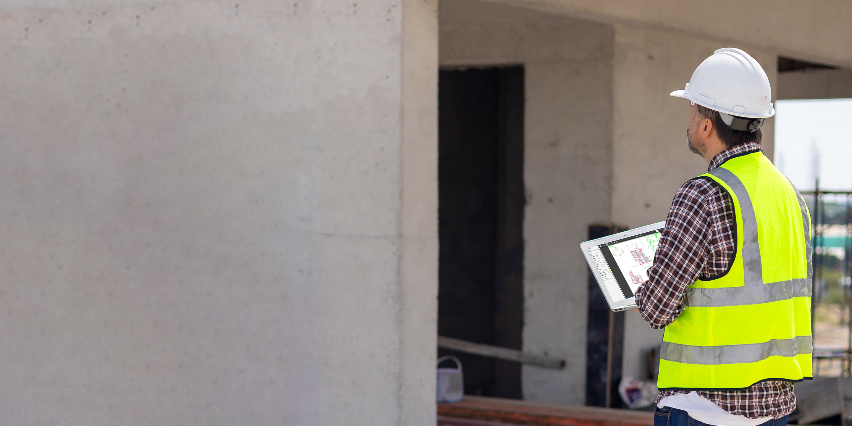 Construction worker in a hard hat using Viewpoint Projects on a tablet to manage building site documentation.