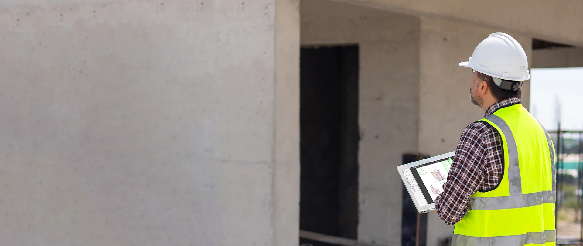 Construction worker in a hard hat using Viewpoint Projects on a tablet to manage building site documentation.