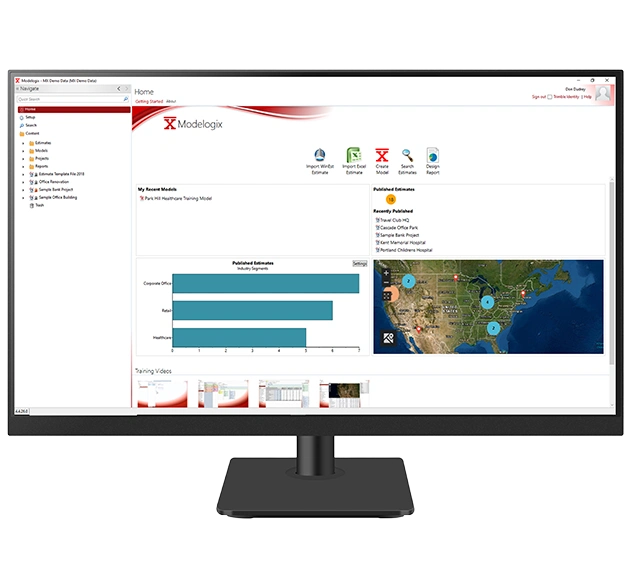 Trimble Modelogix dashboard on a monitor showing estimating data, an industry bar chart, and a map of project sites in the United States.