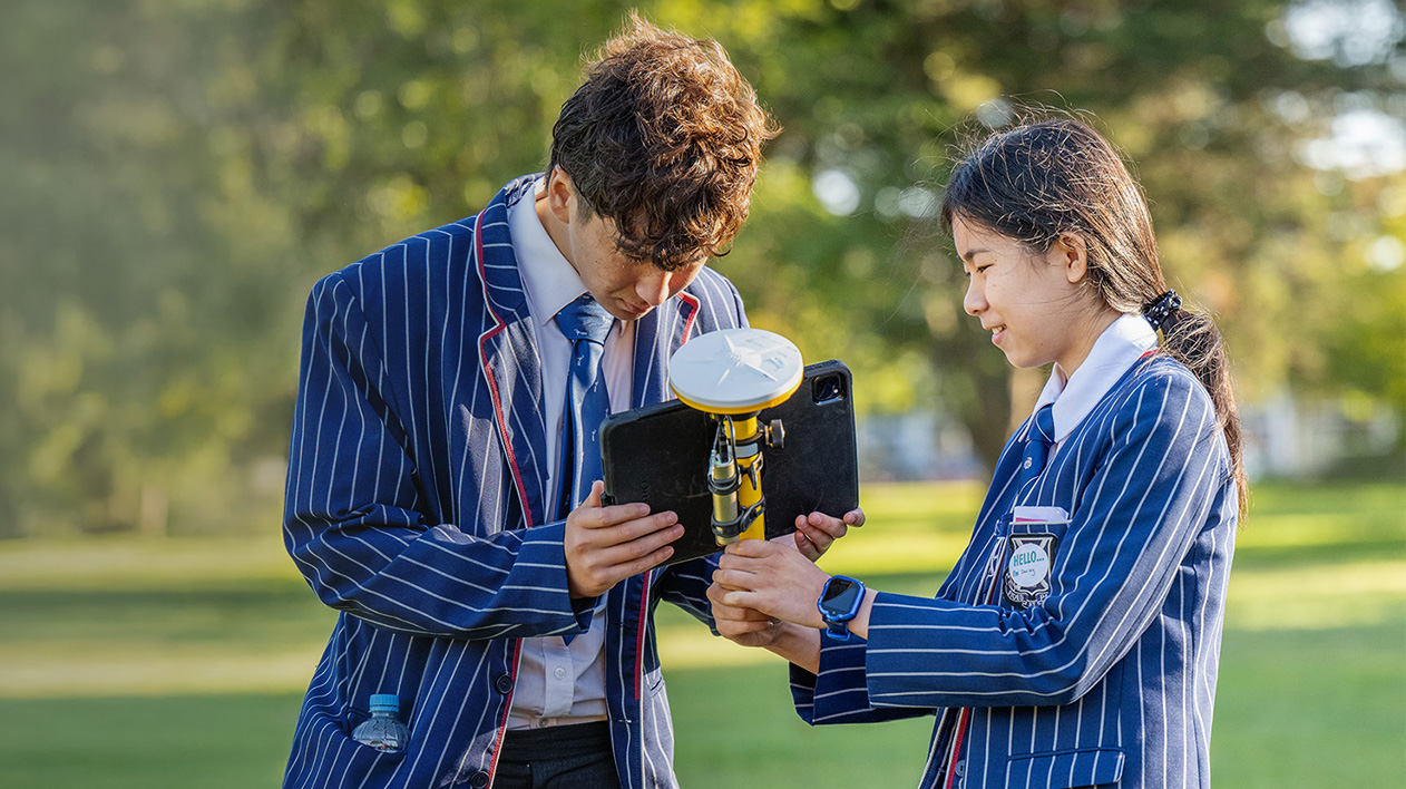Two students in striped blazers using Trimble SiteVision outdoors during a career day in Christchurch, NZ