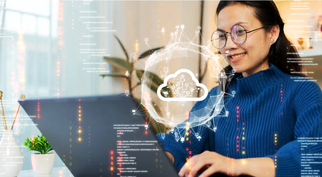 An Asian woman with glasses smiles at her laptop, with a glowing cloud icon and digital code overlays representing cloud computing.