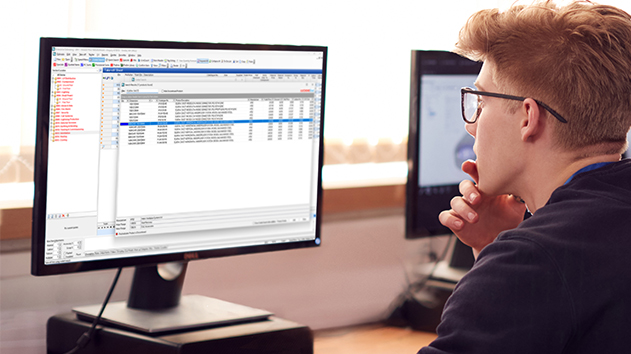 Man looks at a monitor displaying Enterprise Estimating software with a table of product data from Luckins.