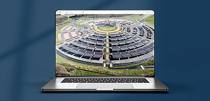 A laptop screen displays an aerial view of a large circular parking lot featuring extensive solar panel canopies over the parking bays.