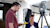A man and woman use a Trimble T10 tablet to operate a Trimble X7 3D laser scanner on a tripod near a silver trailer.